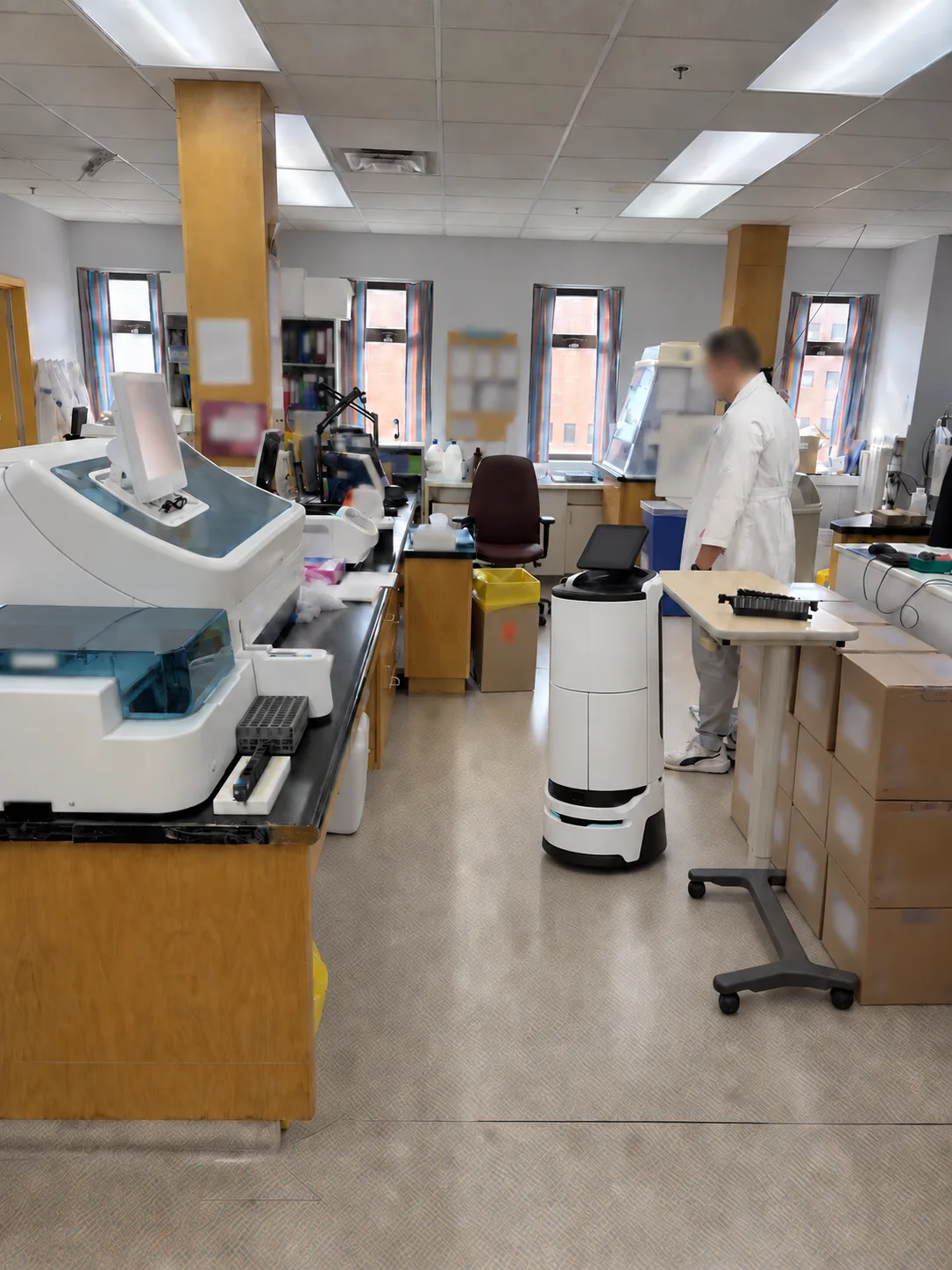Anonymized laboratory staff working with an AI assistant robot